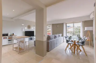 a kitchen and living room with a couch and a table at Cannes 77 - Terrasse, spacieux, clim, paisible in Cannes