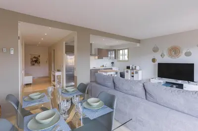 a living room with a couch and a table at Cannes 77 - Terrasse, spacieux, clim, paisible in Cannes