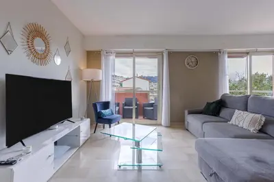a living room with a couch and a tv at Cannes 77 - Terrasse, spacieux, clim, paisible in Cannes