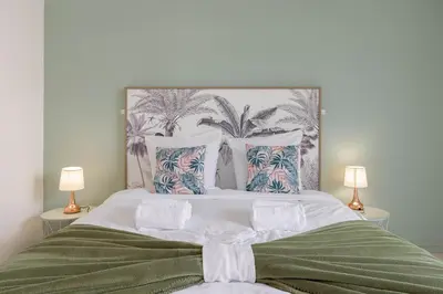 a bedroom with a large bed with two lamps at Cannes 77 - Terrasse, spacieux, clim, paisible in Cannes