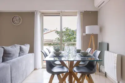 a dining room with a table and chairs and a couch at Cannes 77 - Terrasse, spacieux, clim, paisible in Cannes