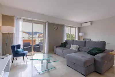 a living room with a gray couch and a glass table at Cannes 77 - Terrasse, spacieux, clim, paisible in Cannes