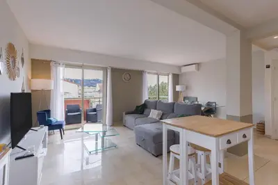 a living room with a couch and a table at Cannes 77 - Terrasse, spacieux, clim, paisible in Cannes