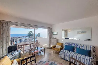 a living room with a couch and a view of the ocean at Henri Camille Agency - Le Cap - 2 bedrooms Apt sea view in Cannes