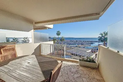 a balcony with a table and a view of the beach at Henri Camille Agency - Le Cap - 2 bedrooms Apt sea view in Cannes