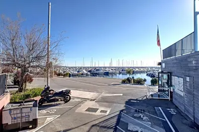 a motorcycle parked in a parking lot next to a building at Henri Camille Agency - Le Cap - 2 bedrooms Apt sea view in Cannes