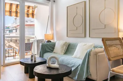 a living room with a couch and two tables at Cannes centre derrière le Martinez in Cannes