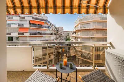 a balcony with a table and chairs and buildings at Cannes centre derrière le Martinez in Cannes