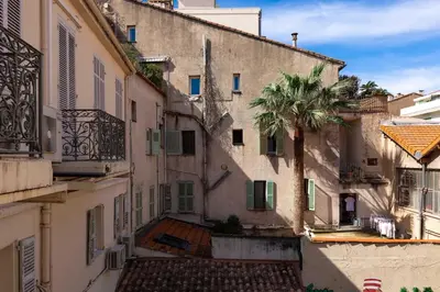 a group of buildings with a palm tree in the middle at Cannes Loft 1 bedroom - 3R in Cannes