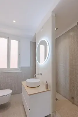 a white bathroom with a sink and a mirror at Cannes Loft 1 bedroom - 3R in Cannes