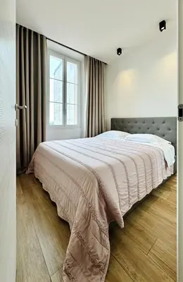 a bedroom with a large bed and a window at Cozy Croisette Retreat Cannes in Cannes
