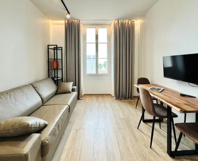 a living room with a couch and a table and a television at Cozy Croisette Retreat Cannes in Cannes
