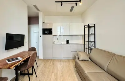 a living room with a couch and a table and a kitchen at Cozy Croisette Retreat Cannes in Cannes