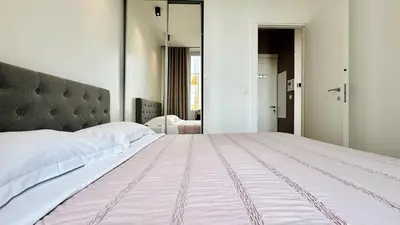 a bedroom with a large bed and a mirror at Cozy Croisette Retreat Cannes in Cannes