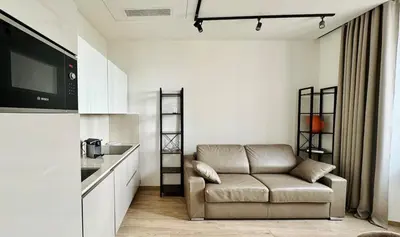 a living room with a couch and a kitchen at Cozy Croisette Retreat Cannes in Cannes