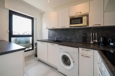 a kitchen with a washing machine and a microwave at Évasion Pointe Croisette, vue mer, plage à une minute in Cannes