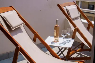 a table with two chairs with a bottle and wine glasses at Évasion Pointe Croisette, vue mer, plage à une minute in Cannes
