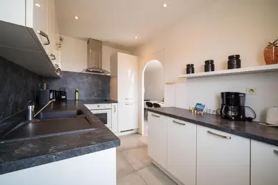 a kitchen with white cabinets and a sink at Évasion Pointe Croisette, vue mer, plage à une minute in Cannes