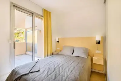 a bedroom with a bed and a sliding glass door at Villa Livia - Citea - Groupe Pierre & Vacances Tourisme Piscine et mer à proximité - Résidence rénovée in Cannes