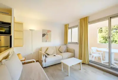 a living room with a couch and a table at Villa Livia - Citea - Groupe Pierre & Vacances Tourisme Piscine et mer à proximité - Résidence rénovée in Cannes