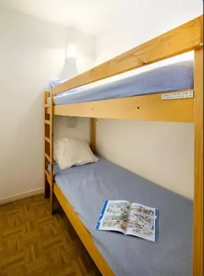 a bunk bed with two books on the bottom bunk at Villa Livia - Citea - Groupe Pierre & Vacances Tourisme Piscine et mer à proximité - Résidence rénovée in Cannes