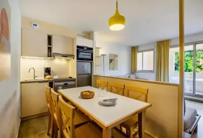 a kitchen and dining room with a table and chairs at Villa Livia - Citea - Groupe Pierre & Vacances Tourisme Piscine et mer à proximité - Résidence rénovée in Cannes