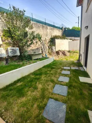 a walkway with stones in the grass next to a building at studio la mimosette in Cannes