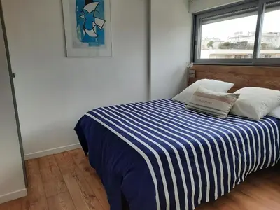 a bedroom with a bed with a blue and white striped blanket at One bedroom apartment Palm Beach in Cannes