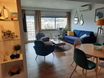a living room with a blue couch and a table at One bedroom apartment Palm Beach in Cannes