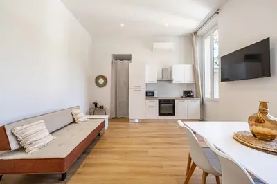 a white living room with a couch and a table at LE COSY un havre de paix près de la Croisette in Cannes