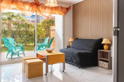 a bedroom with a bed and a table and chairs at Studio dans résidence neuve - Terrasse et jardin in Cannes