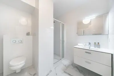a white bathroom with a toilet and a shower at Studio dans résidence neuve - Terrasse et jardin in Cannes