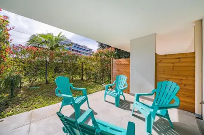 three blue chairs sitting on a patio with a view at Studio dans résidence neuve - Terrasse et jardin in Cannes