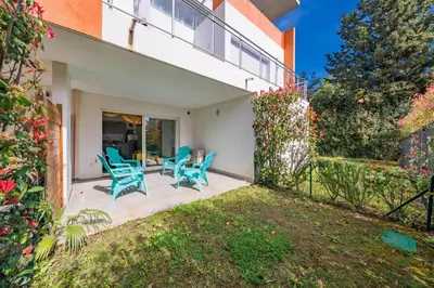 a home with a patio with blue chairs at Studio dans résidence neuve - Terrasse et jardin in Cannes