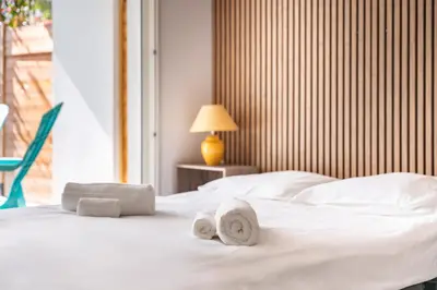 a bedroom with a white bed with towels on it at Studio dans résidence neuve - Terrasse et jardin in Cannes