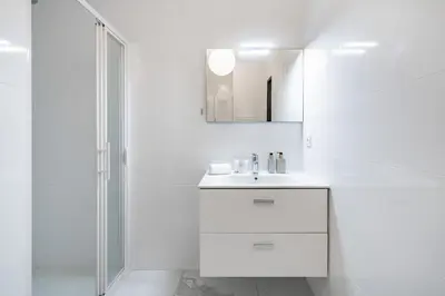 a white bathroom with a sink and a mirror at Studio dans résidence neuve - Terrasse et jardin in Cannes