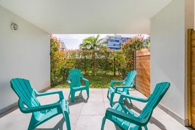 three green chairs on a patio with a fence at Studio dans résidence neuve - Terrasse et jardin in Cannes