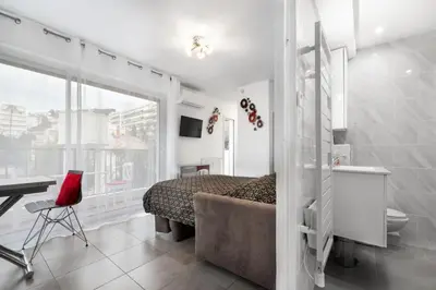a bedroom with a bed and a desk and a window at Charmant Studio - Calme - Croisette & Plage à 7 min in Cannes