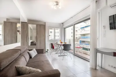 a living room with a large couch and a table at Charmant Studio - Calme - Croisette & Plage à 7 min in Cannes