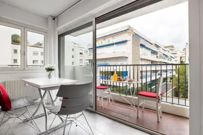 a room with a balcony with a table and chairs at Charmant Studio - Calme - Croisette & Plage à 7 min in Cannes