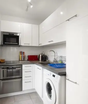 a kitchen with white cabinets and a washer and dryer at Charmant Studio - Calme - Croisette & Plage à 7 min in Cannes