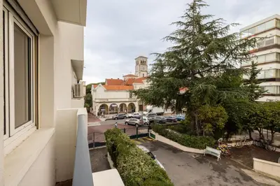 a view of a street with a tree and a building at Charmant Studio - Calme - Croisette & Plage à 7 min in Cannes