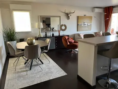 a kitchen and living room with a table and chairs at Apartment in park with pool in Cannes