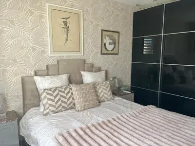a bedroom with a bed and a wall at Apartment in park with pool in Cannes