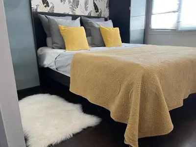 a bedroom with a bed with yellow pillows and a white rug at Apartment in park with pool in Cannes