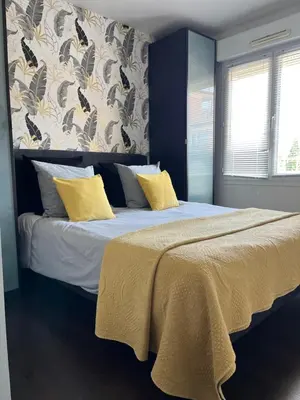 a bedroom with a large bed with yellow pillows at Apartment in park with pool in Cannes