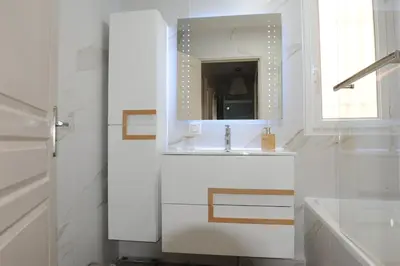 a white bathroom with a sink and a mirror at Apartment in park with pool in Cannes