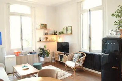 a living room with a tv and two windows at Charming Apartment Cannes City Center and Beaches in Cannes