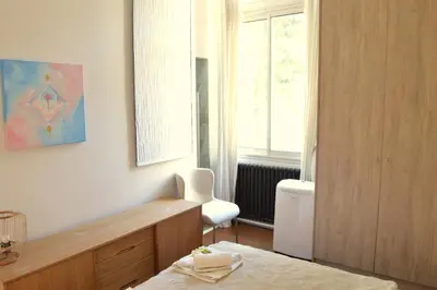 a room with a bed and a chair and a window at Charming Apartment Cannes City Center and Beaches in Cannes