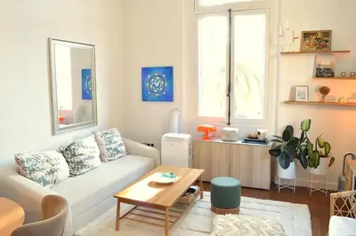 a living room with a white couch and a table at Charming Apartment Cannes City Center and Beaches in Cannes